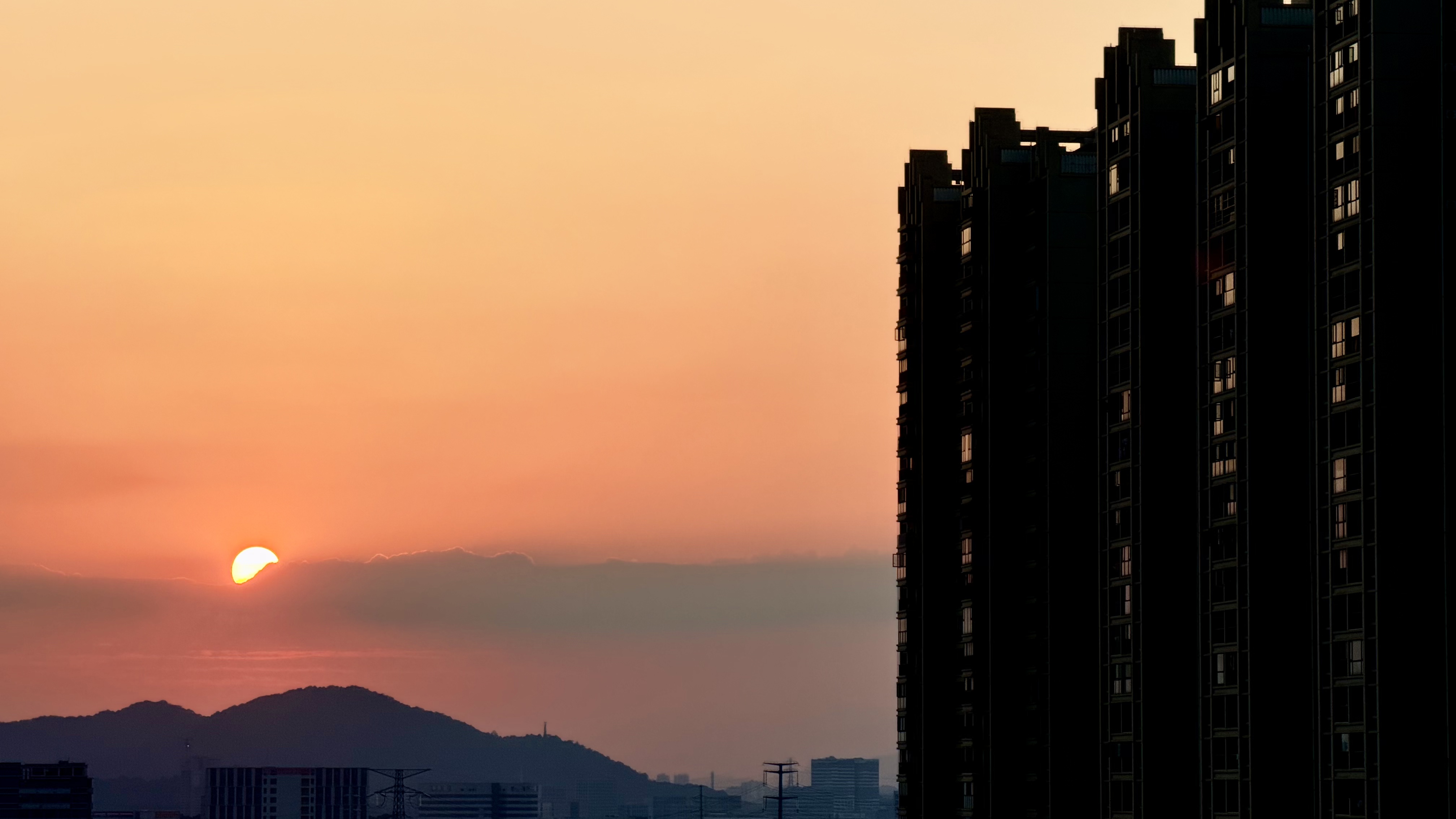 城市楼宇旁的橙粉色日落